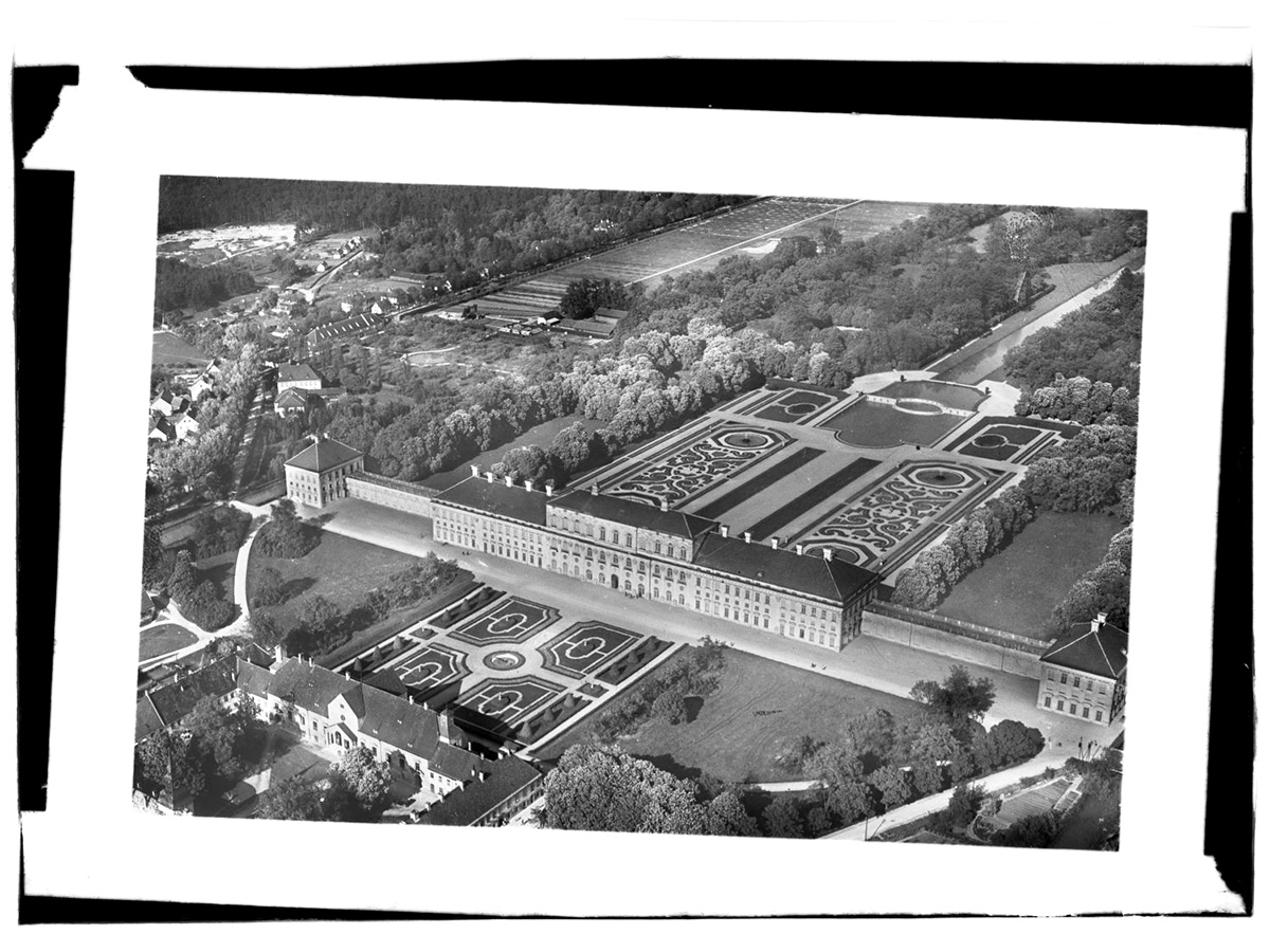 Fotoplatte der Schlossanlage Schleißheim, 1930er Jahre Zu sehen ist das symmetrisch angelegte Schloss mit dem barocken Schlossgarten auf einem Schrägliftbild in schwarz-weiß.