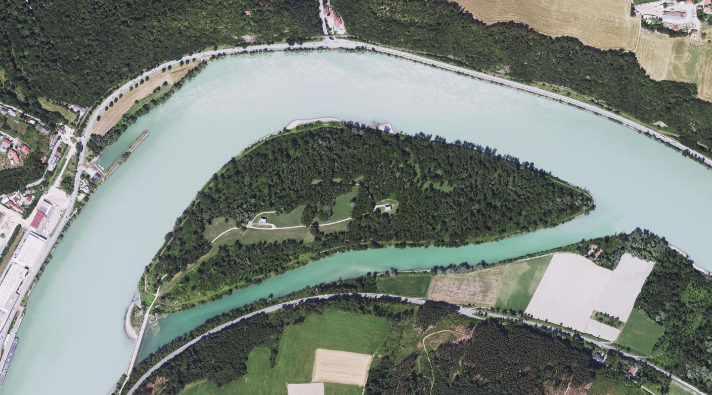 die Donau fließt in einem Bogen von links unten nach rechts mitte;im Zentrum eine bewaldete Insel