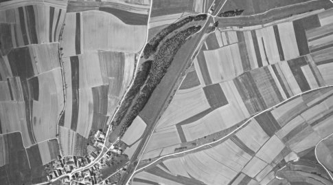 Schwarzweißes Luftbild mit vielen Feldern, ein paar Häusern und einem Graben.